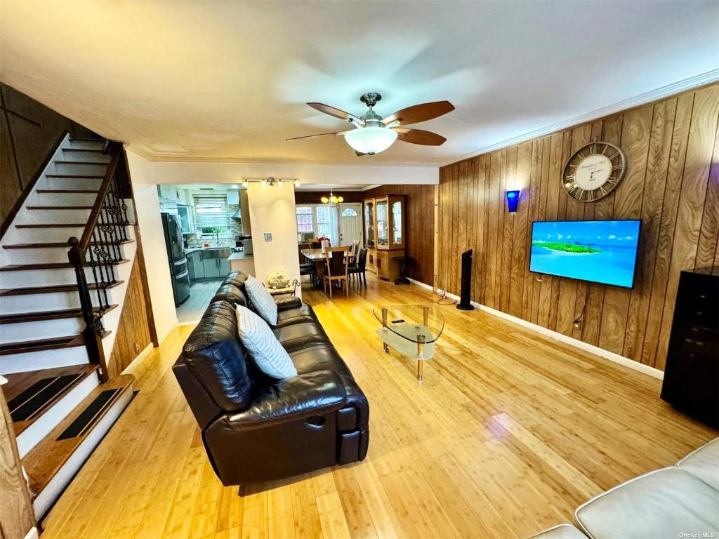 a living room with a couch and a ceiling fan at LGA airport 3 mins, 3 BR Duplex House, Parking and private backyard, 9mins subway! in East Elmhurst