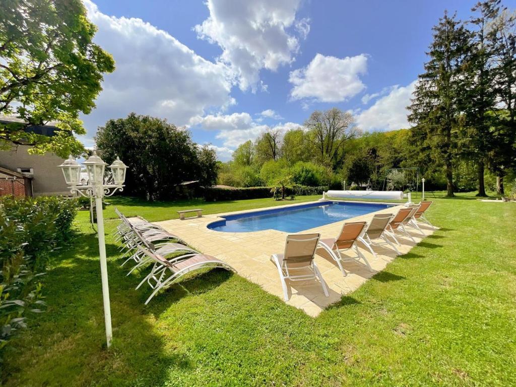 un groupe de chaises assises autour d'une piscine dans l'établissement Le Domaine du Cerf - Gites, nature et Spa, à Saint-Ouen-les-Vignes