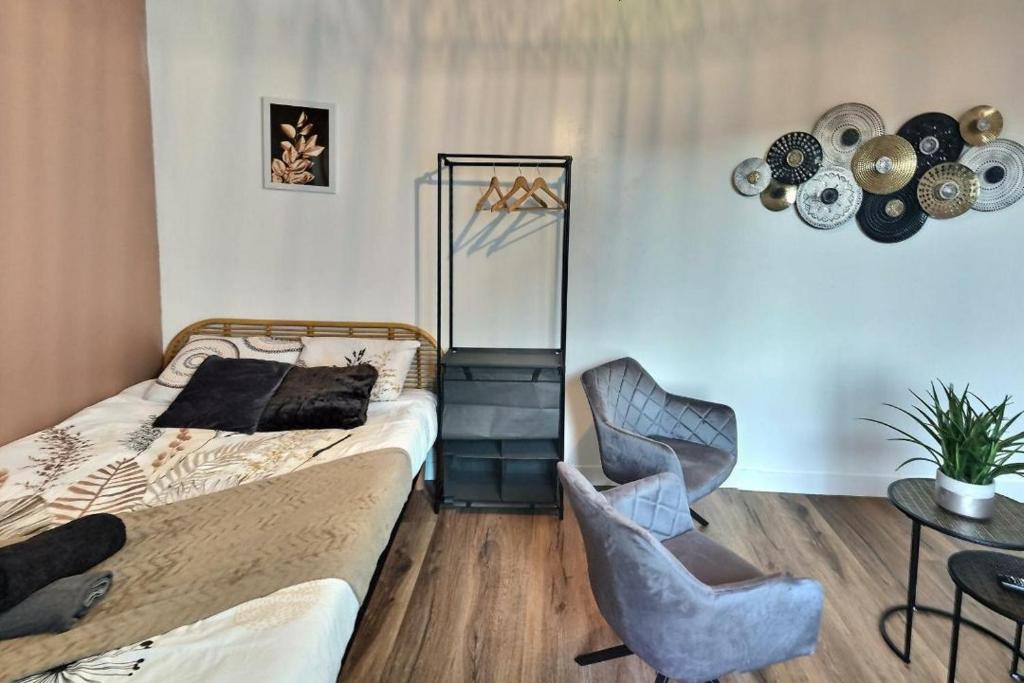 une chambre avec un lit, une chaise et une table dans l'établissement Oasis Urbaine, à Évreux