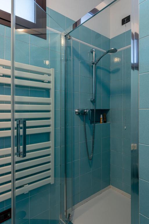 łazienka z prysznicem z niebieskimi kafelkami w obiekcie Il Sogno Apartments w mieście Desenzano del Garda