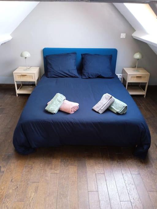 - un lit bleu avec 3 oreillers au-dessus dans l'établissement Maisonnette en Val de Loire, à Messas