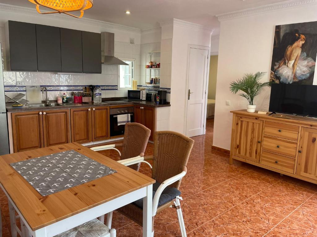 a kitchen with a table with chairs and a television at San juan 2 bedrooms 27 in Playa de San Juan