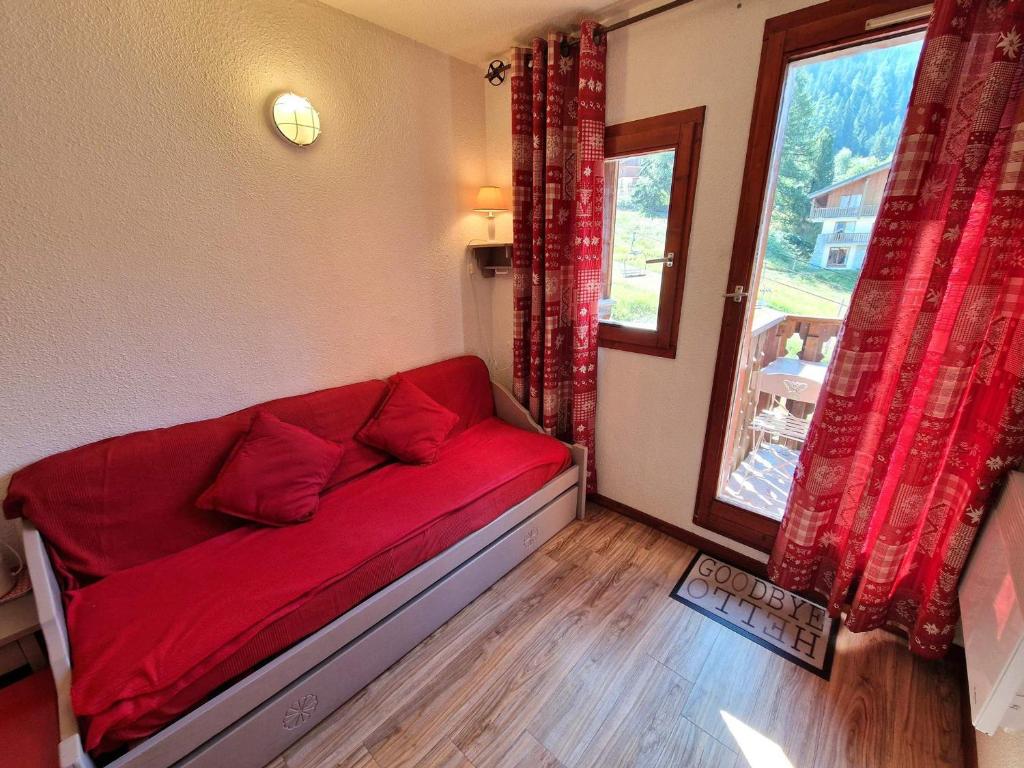 - un canapé rouge dans une chambre avec fenêtre dans l'établissement Charmant studio 2-3 pers avec balcon à Valfréjus - FR-1-265-214, à Valfréjus