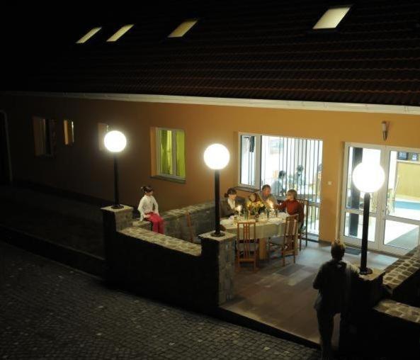 eine Gruppe von Menschen, die an einem Tisch in einem Restaurant sitzen in der Unterkunft Pension Harmonia in Miercurea Ciuc