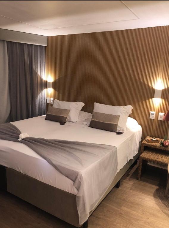 a bedroom with a large bed with white sheets and pillows at Fortaleza 703--Fortaleza 713 in Fortaleza