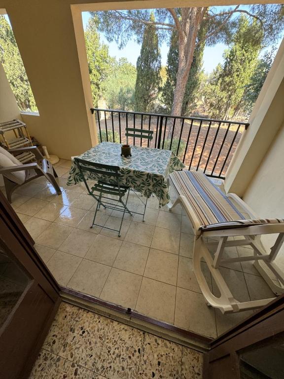 d'un balcon avec une table, un banc et une fenêtre. dans l'établissement Studio proche du centre-ville, à LʼÎle-Rousse