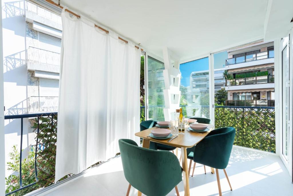 une salle à manger avec une table et des chaises et une grande fenêtre dans l'établissement Bright 1-Br Apartment Walk to the Beach, à Cannes