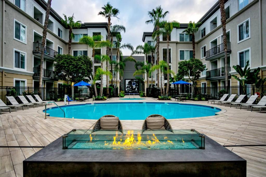 ein Swimmingpool mit zwei Liegestühlen vor einem Gebäude in der Unterkunft Luxe Marina Del Rey Apartment,Parking, Gym, Pool, jacuzzi,BBQ in Los Angeles