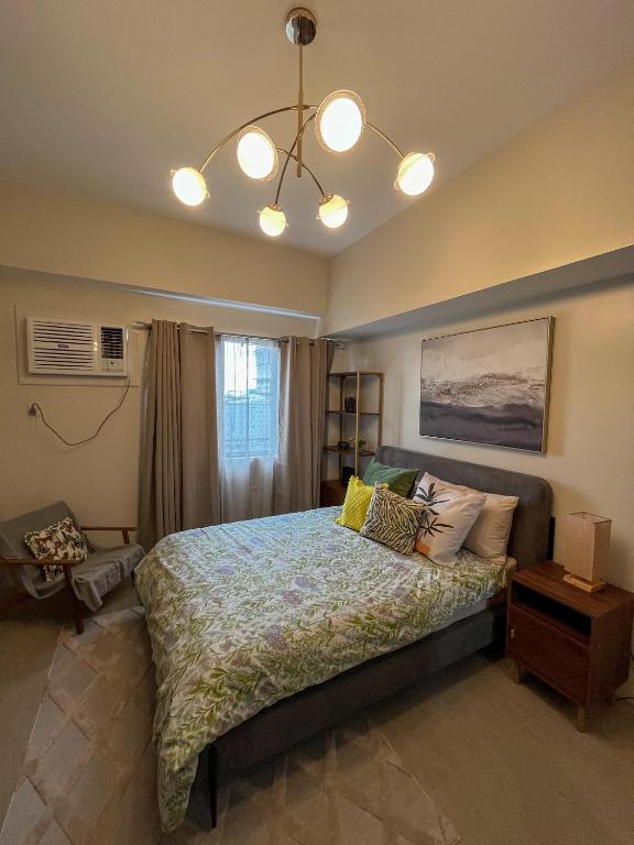 Un dormitorio con una cama y una lámpara de araña. en Life Luxury Lodgings near IT PARK, en Cebú