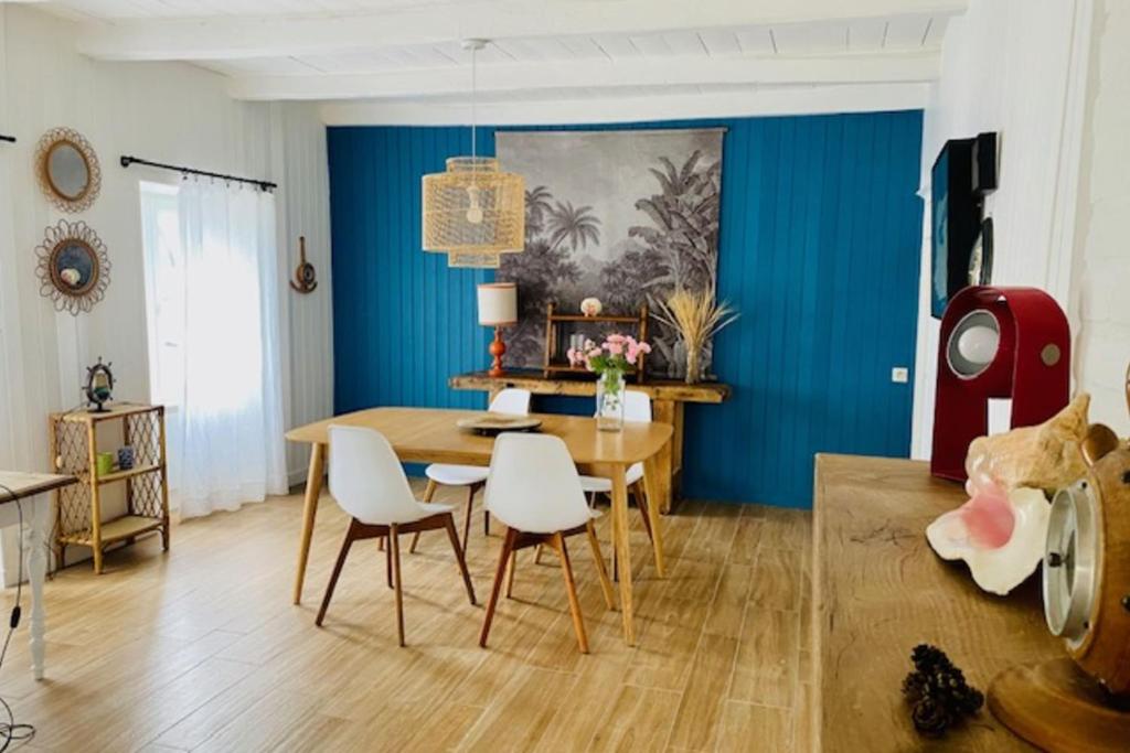 a dining room with blue walls and a table and chairs at Charming house near Ile de Ré with terrace in Nieul-sur-Mer