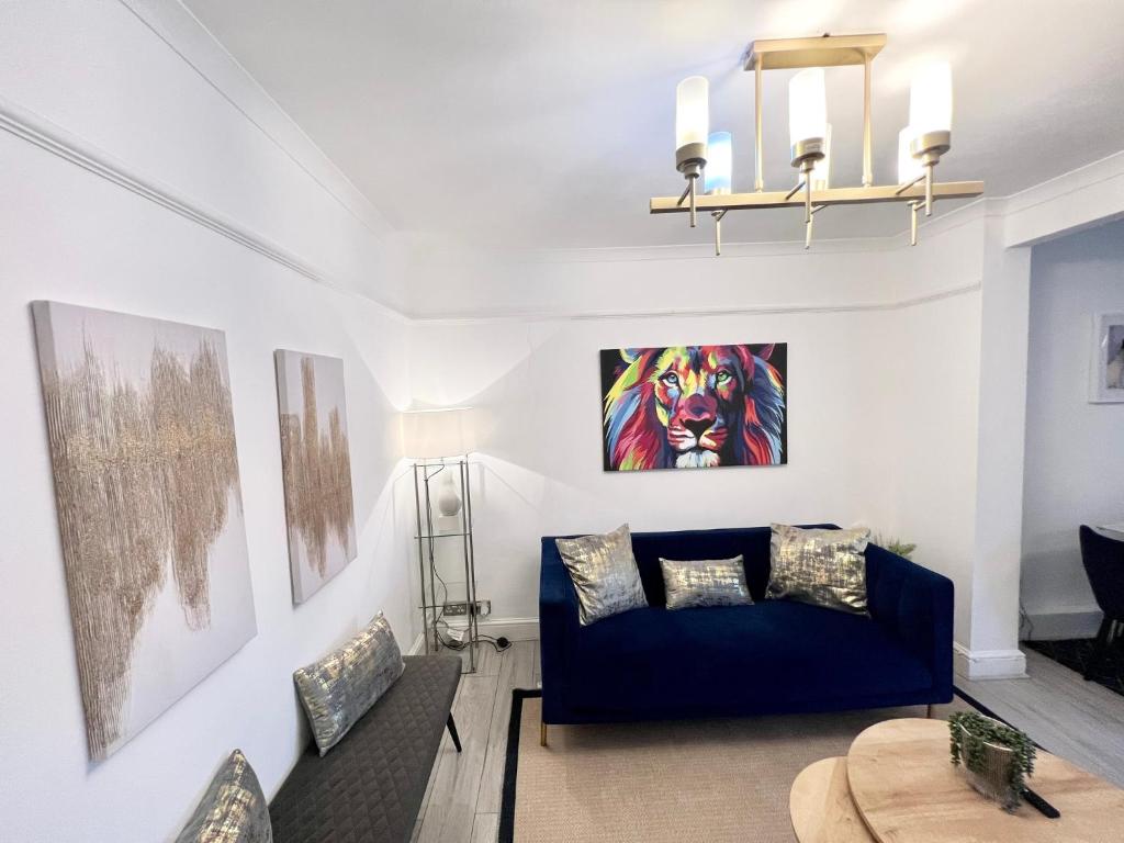 ein Wohnzimmer mit einem blauen Sofa und einem Tisch in der Unterkunft Modern 2 bed near mall and parking in Golders Green