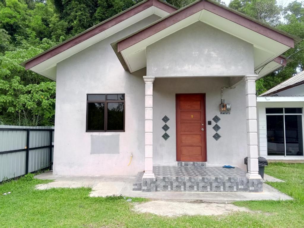 a small white house with a red door at Homestay Idaman B B with 2 room aircond 2 Quen Bed and Not Sharing Room -Privacy in Kuala Terengganu