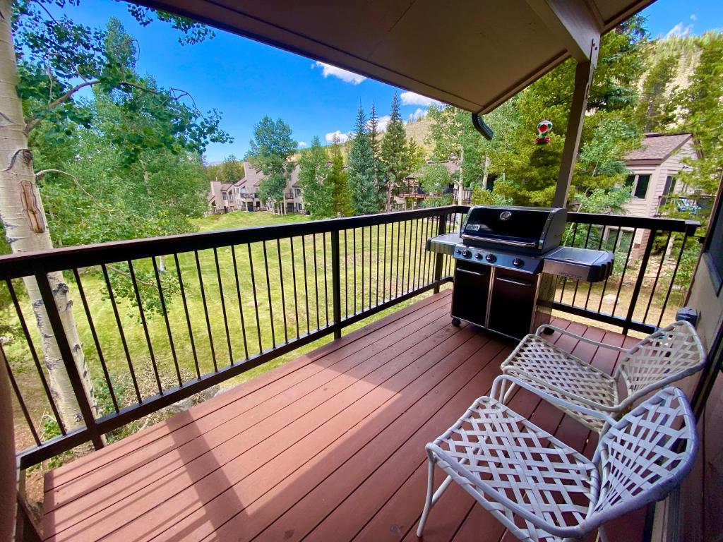 a screened in porch with a grill and chairs at Quicksilver 1626 by SummitCove Lodging in Keystone