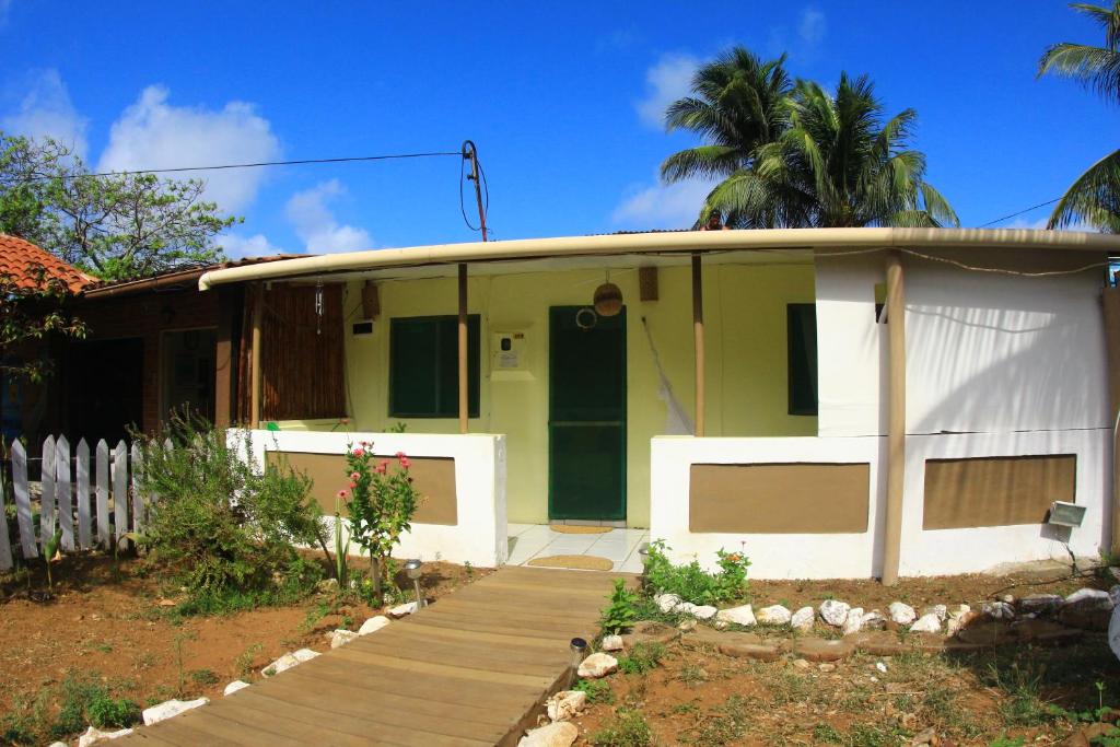 uma casa verde e branca com um alpendre de madeira em Casa da Albertina em Fernando de Noronha