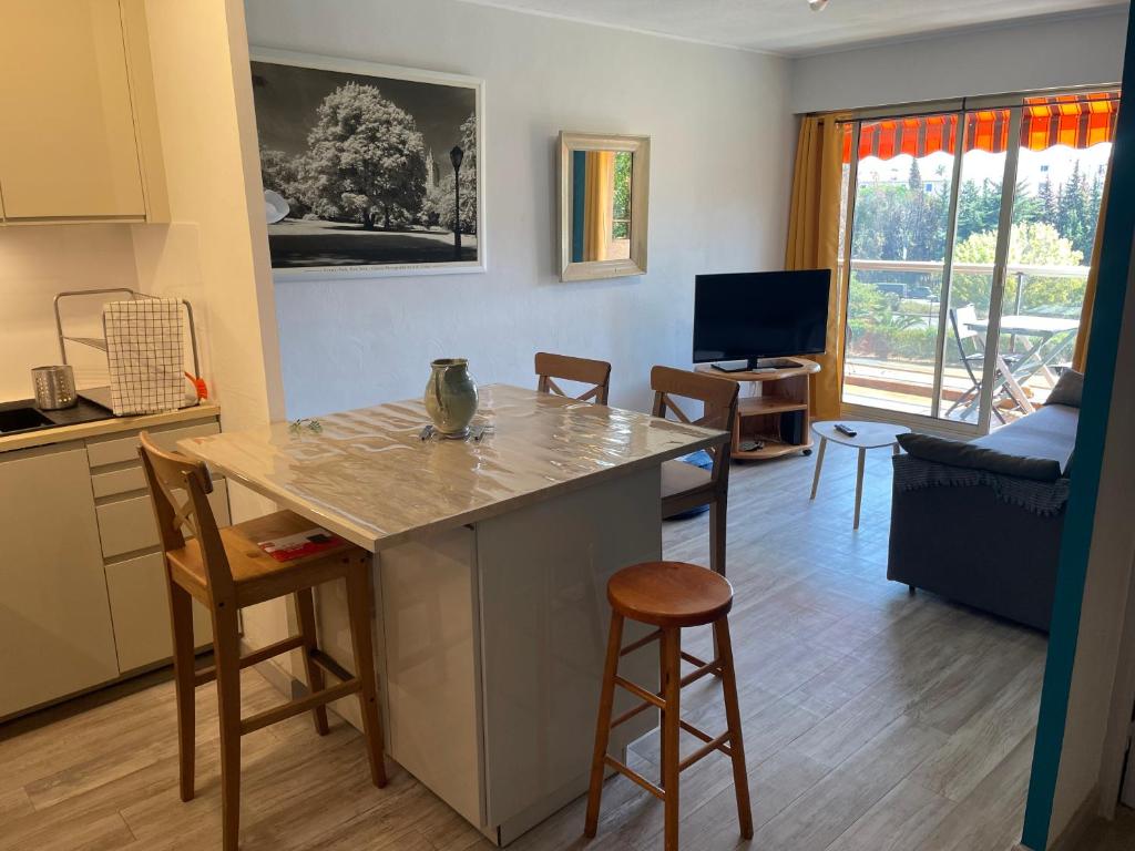 une cuisine et un salon avec une table et des chaises dans l'établissement Bel appartement à Hyeres centre 2 à 3 personnes, à Hyères