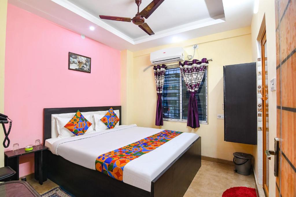 a bedroom with a large bed with pink walls at Comfort Stays Kolkata airport in Salua