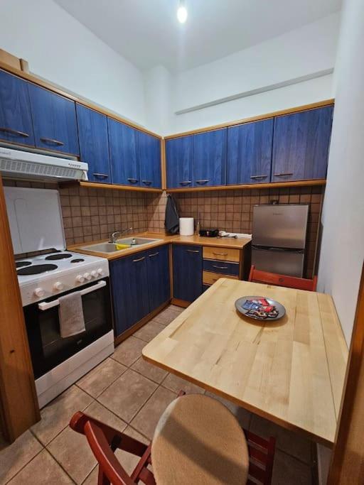 a kitchen with blue cabinets and a table with a plate on it at KT Apartment in Drama