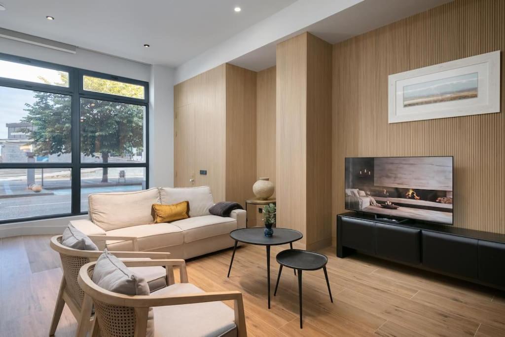 a living room with a couch and a tv at Luxury Marina Loft in Gijón