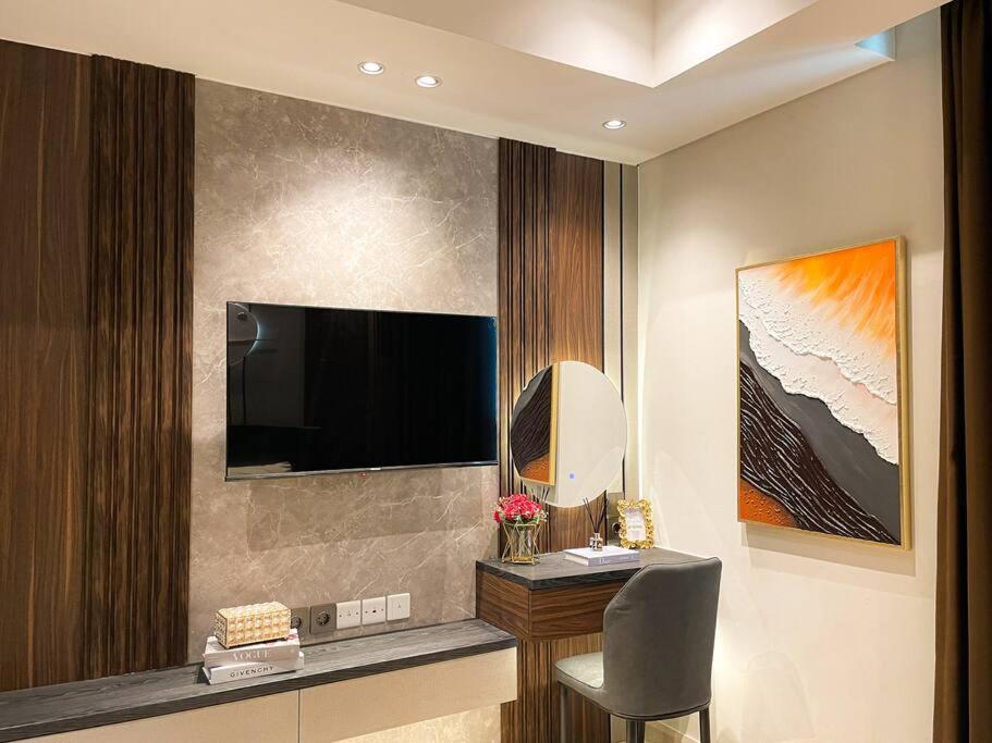 Zimmer mit einem TV, einem Stuhl und einem Schreibtisch. in der Unterkunft Luxurious La Luna at Gold Coast Sea View in Jakarta