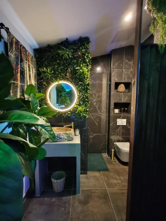 La salle de bains est pourvue d'un mur vert avec un lavabo et un miroir. dans l'établissement La Jungle Room, à Rognac