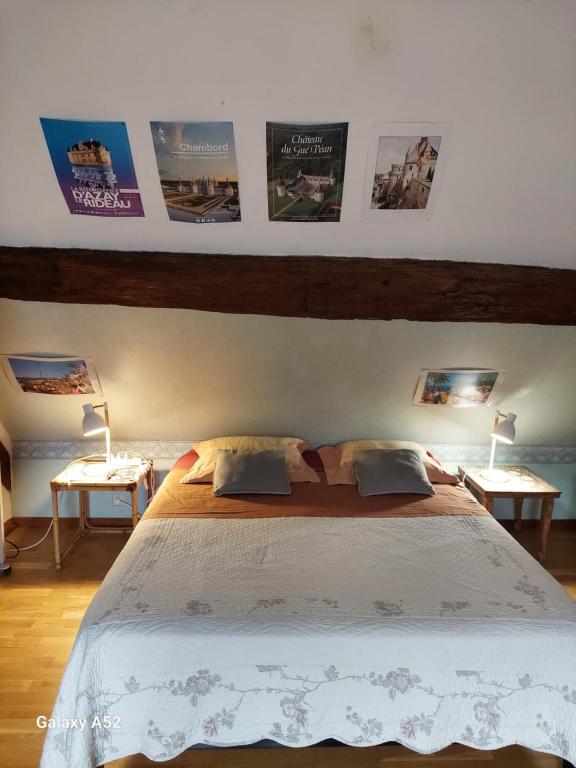 a bedroom with a large bed with posters on the wall at Chambres dans longère particulière in Dierre