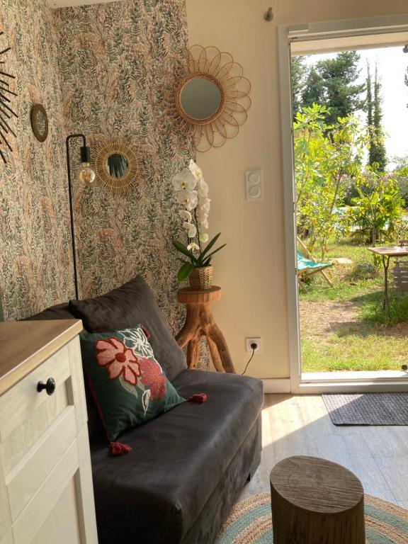 un salon avec un canapé et une porte coulissante en verre dans l'établissement Studio indépendant calme et climatisé en campagne, au Thor