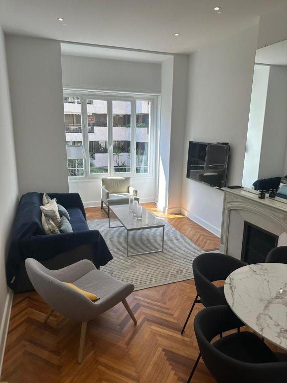 un salon avec un canapé bleu et une cheminée dans l'établissement Golden House Cannes, à Cannes