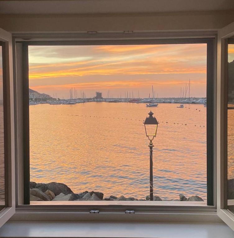 a window with a view of the water and a street light at Casa Cotone 9 in Marciana Marina