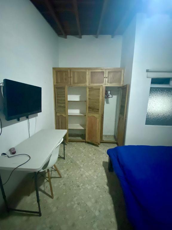 a room with a desk with a tv and a bed at Residencia Dual Retiro Urbano in Envigado