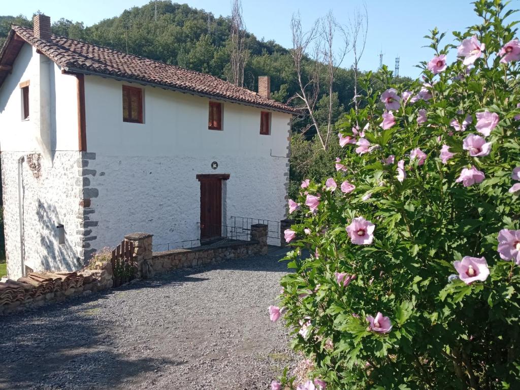 a white building with pink flowers in front of it at Molino De Pradillo in Pradillo