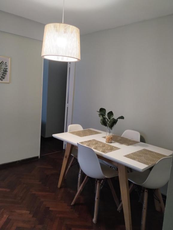 a white table with chairs and a potted plant on it at Departamento céntrico muñecas in San Miguel de Tucumán