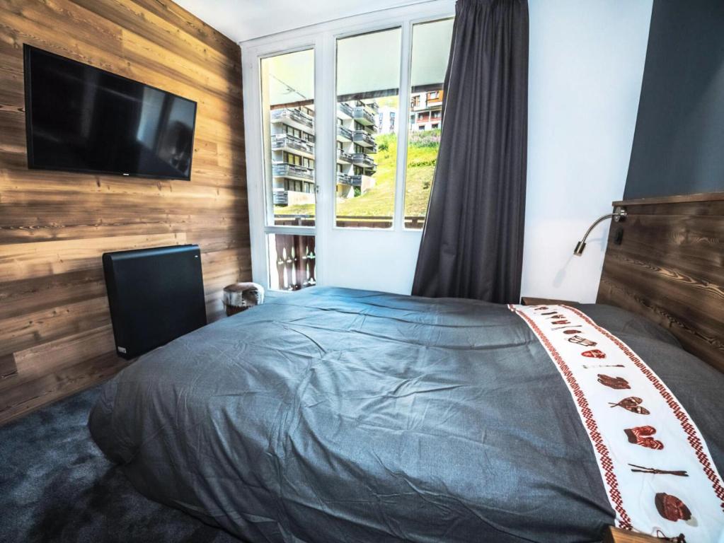 sypialnia z łóżkiem i telewizorem z płaskim ekranem w obiekcie Résidence Rond Point Des Pistes B - Appartement rénové·Départ et retour ski aux pieds· MAE-2414 w mieście Tignes