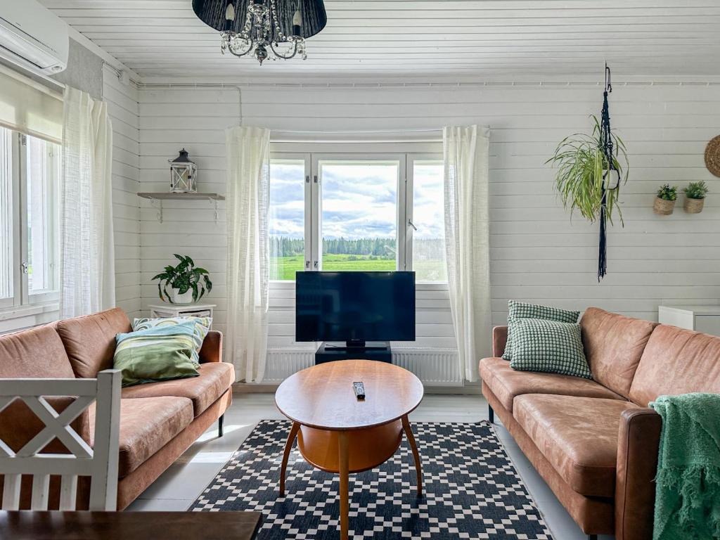 a living room with a couch and a tv at Maalaistalo maatilamiljöössä in Haapavesi