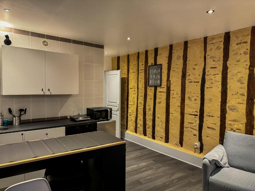 une cuisine avec un mur en bois récupéré dans l'établissement Appartement T1 Bis - Haute-Ville, à Auch