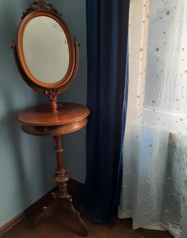a mirror on a wooden stand next to a blue curtain at Anna Luise in Rudolstadt