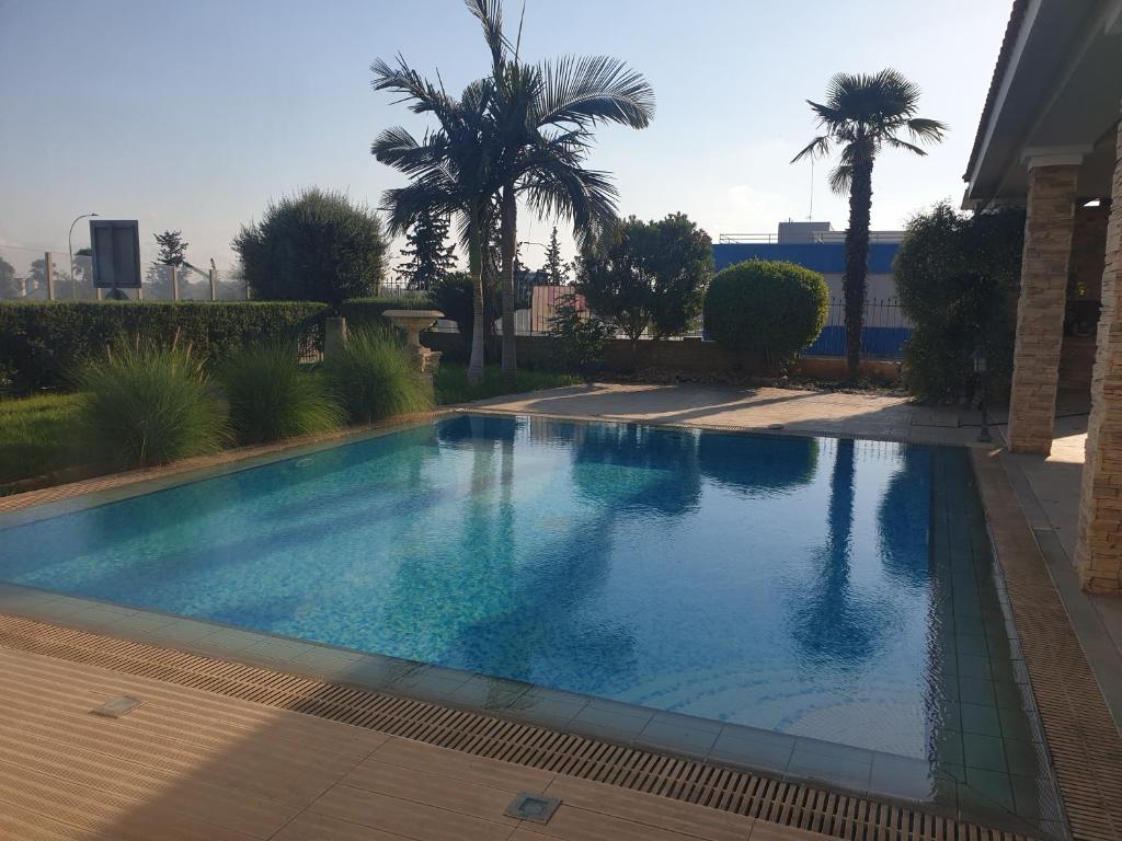 a swimming pool in a yard with palm trees at Beautiful spacious house with swimming pool in Limassol