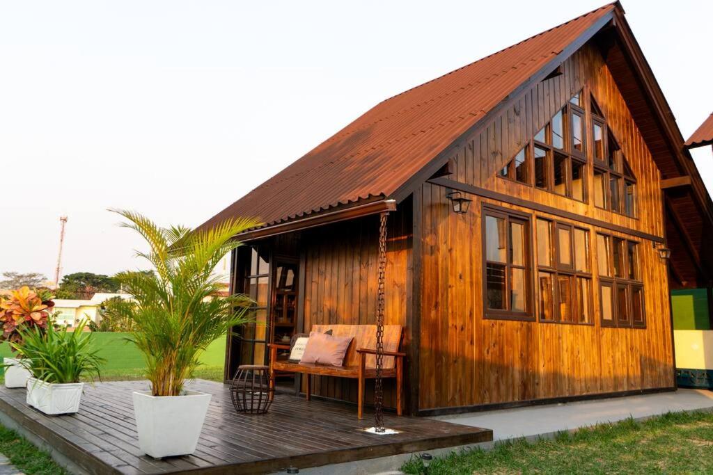a small wooden house with a bench on a deck at Recanto AlceNegro in Miguel Pereira