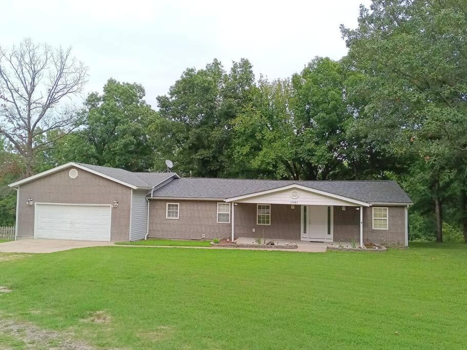 Una casa con un césped verde delante de ella. en A home away from Home, Near Fort Leonard Wood, en Waynesville