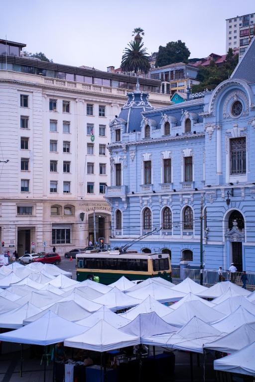 a large building with white tents in front of it at Hotel Reina Victoria Valparaíso in Valparaíso