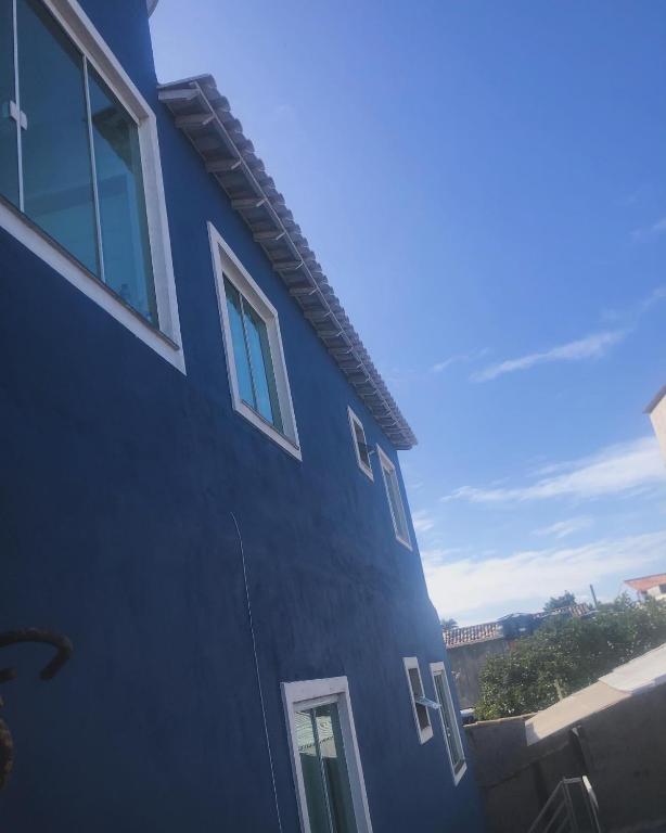 a blue building with windows on the side of it at Céu e mar Rua marechal Hermes da Fonseca 37 Praia Grande centro Espaço todo reservado para hóspede in Arraial do Cabo