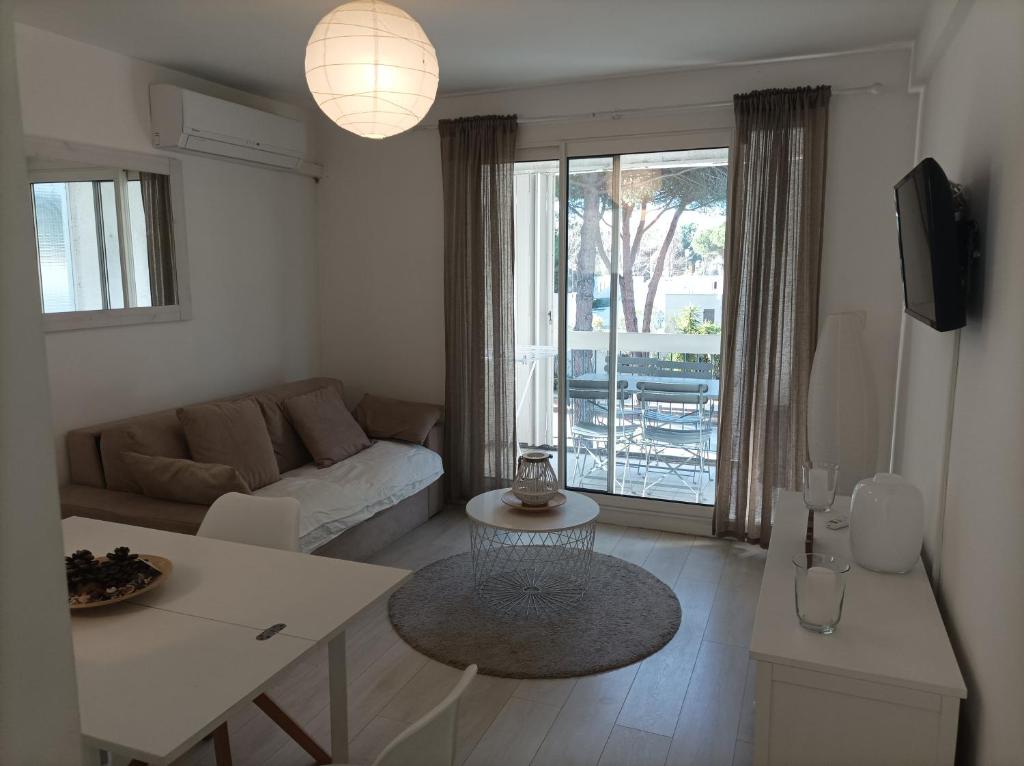 un salon avec un canapé et une table dans l'établissement Agréable Appartement Proche Plage - Linge de lit et Toilettes en option, à La Grande Motte