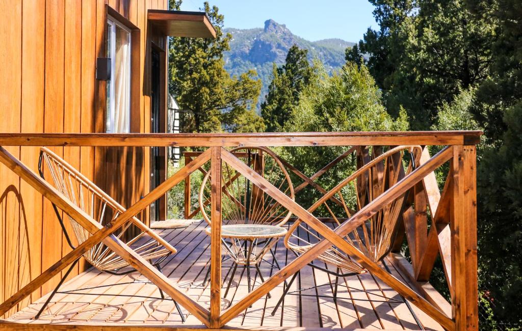 a wooden deck with a table and chairs on a house at Refugio del Hornero Norte in San Carlos de Bariloche