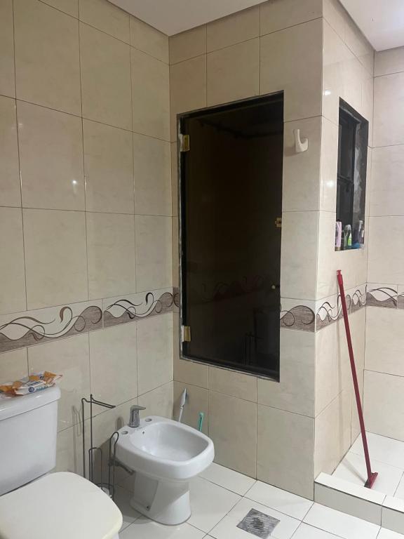 a bathroom with a toilet and a sink at Habitacion privada en casa familiar in San Bernardino