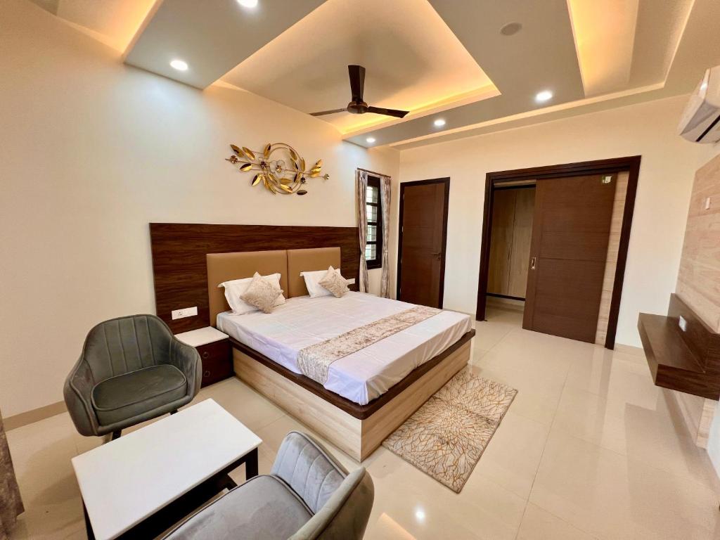 a bedroom with a bed and a chair at Vaidehi Resorts in Ayodhya