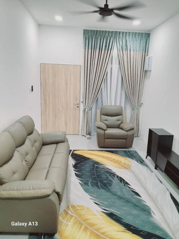 a living room with a couch and a chair at Nova Stay SP in Sungai Petani