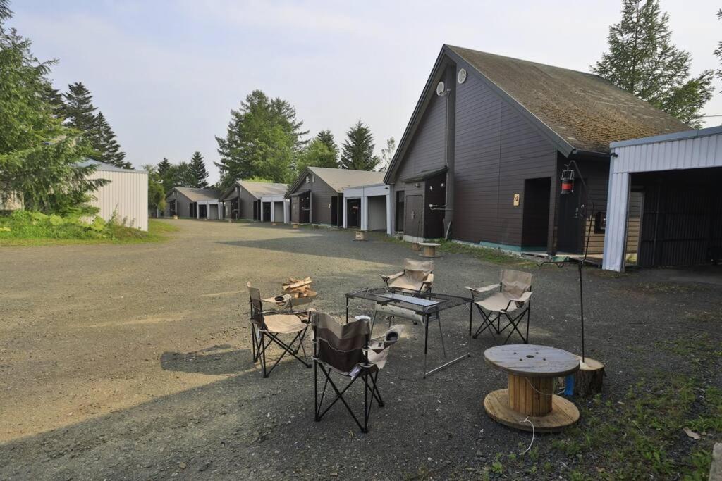a group of chairs and tables in front of a building at Starry Sky Cottage 13 in Kitami