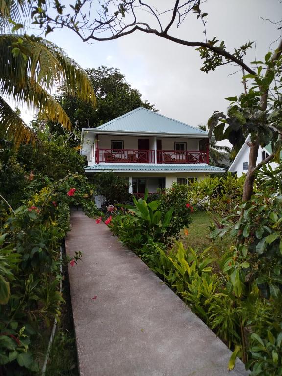 a house with a pathway in front of it at Lucy's guesthouse in La Digue