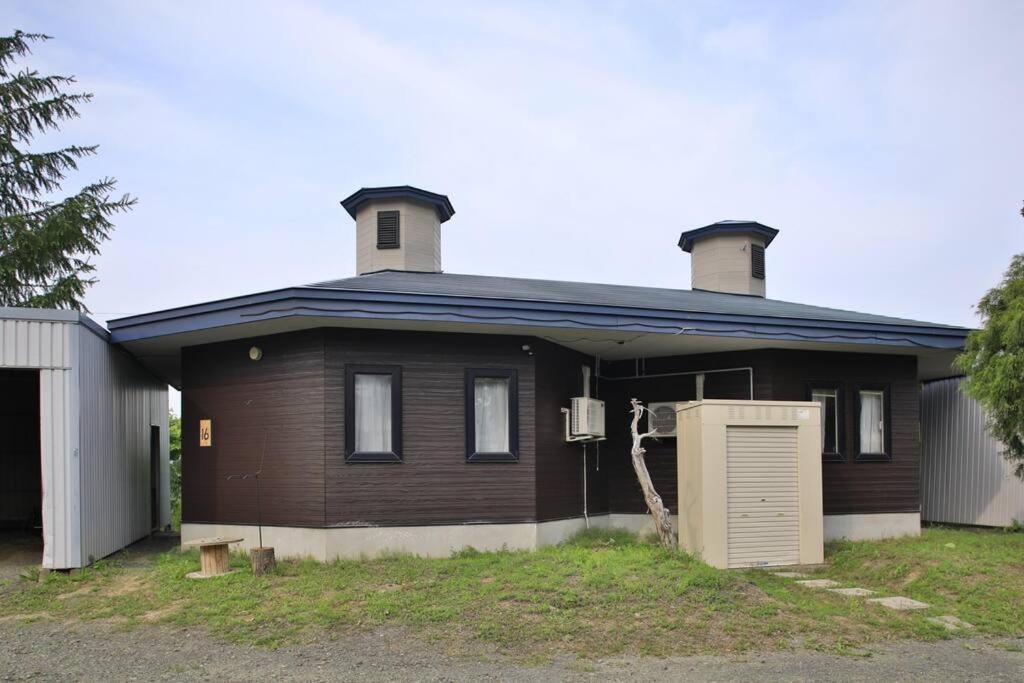 a brown house with two chimneys on top of it at Starry Sky Cottage 16 in Bihoro