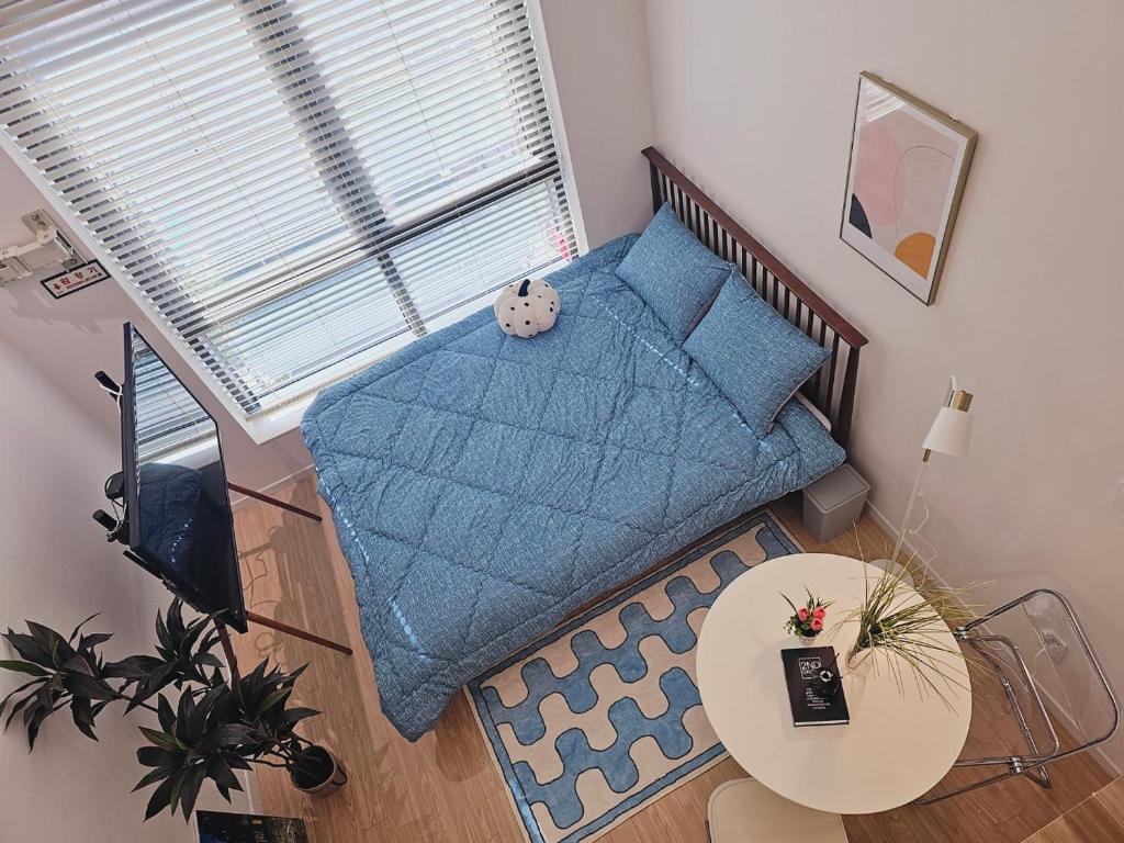 a living room with a blue couch and a table at Sillim Sindaebang Station Gocheok Sky Dome Lovely house in Seoul
