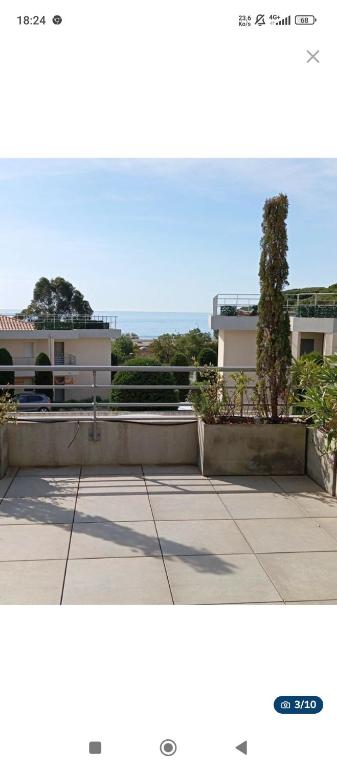 une photo d'un bâtiment avec un arbre devant lui dans l'établissement 2 pièces terrasse vue mer, piscine, parking, à Sainte-Maxime
